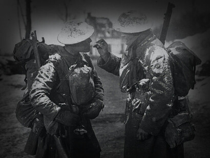 A british soldier is trying to light the cigarette of his fellow, WWI