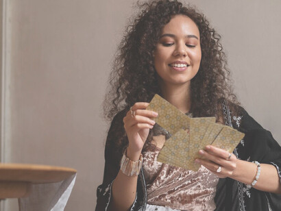 A woman consulting Oracle cards at a table