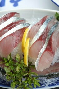 A platter of gleaming raw mackerel sashimi artfully arranged with head and tail intact, showcasing Jeju’s devotion to “hwe” and the island’s celebration of the freshest catch