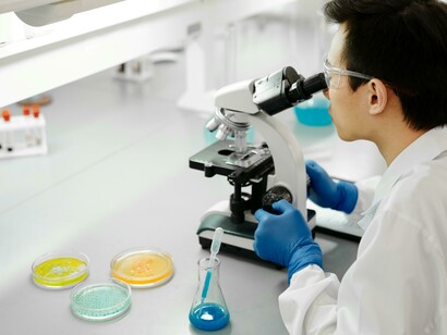A scientist studies plant cells through a microscope, highlighting breakthroughs in bioengineered crops and next-generation farming technologies