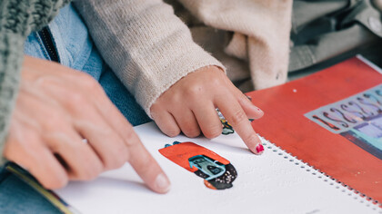 Professora lê história em braile para aluninha