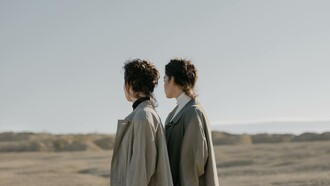 Two people wearing the same clothes and standing in the same way