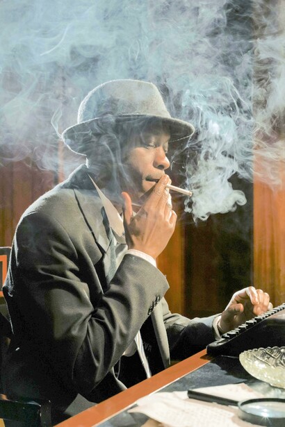 Detetive fuma um cigarro enquanto escreve