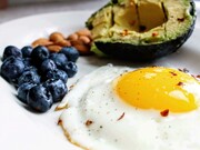 A fresh composition of an egg, blueberries, nuts, and avocado — a wholesome Paleo-inspired breakfast