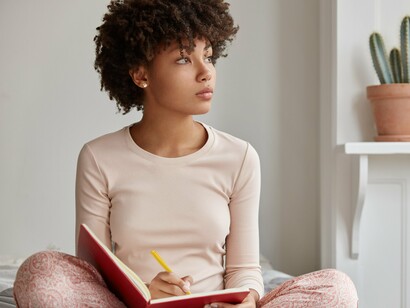 The act of focused writing emphasizes the accessibility of timed journaling, requiring only a notebook and pen to begin the process of emotional processing