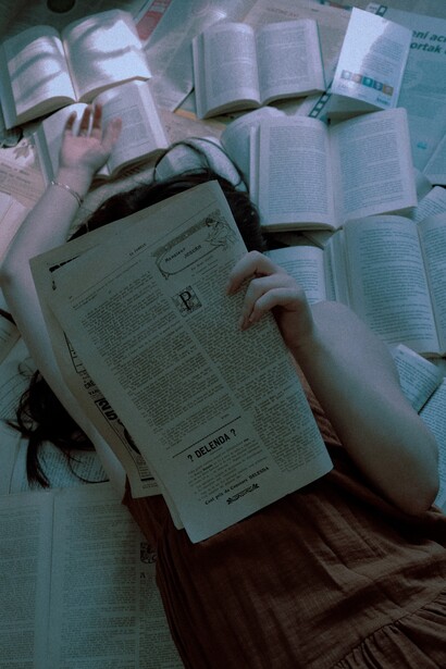 A girl reading, while laying down and relaxing