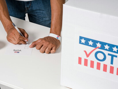 A person filling a voting ballot