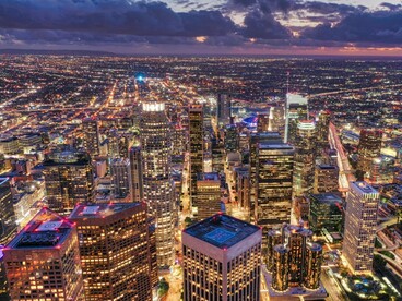 The skyscrapers of downtown Los Angeles rising against the evening sky, symbolizing the city's constant transformation