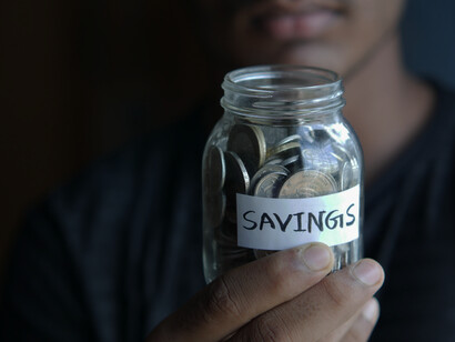 A man holds his savings jar