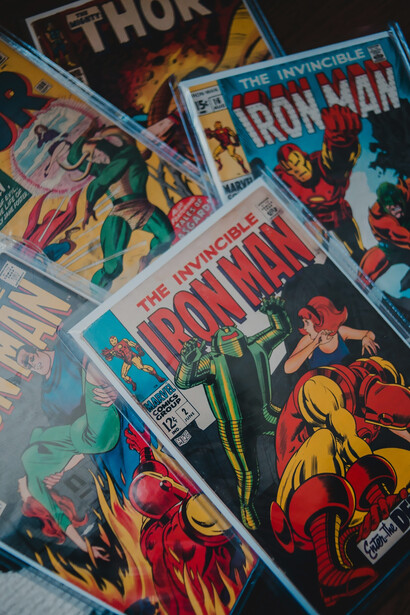 Iron Man, Thor, and Batman cartoon books stacked for display
