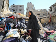 A woman navigates the ruins of her former home, a poignant image of resilience amid widespread destruction during war