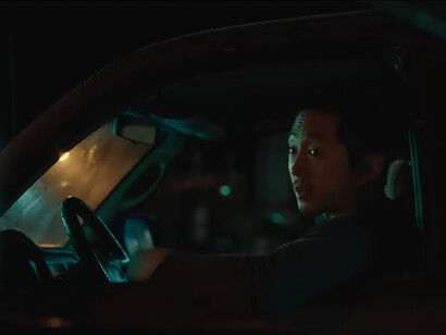 The two main characters having a conversation in their respective cars