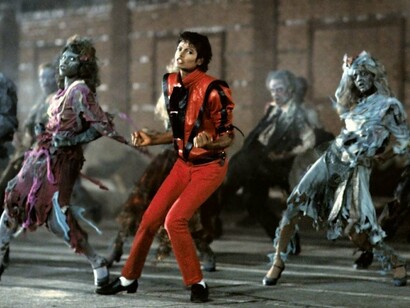Michael Jackson durante uma cena do videoclipe de Thriller, produção que revolucionou a relação entre música e narrativa visual. O figurino da era se tornou uma referência duradoura na cultura pop