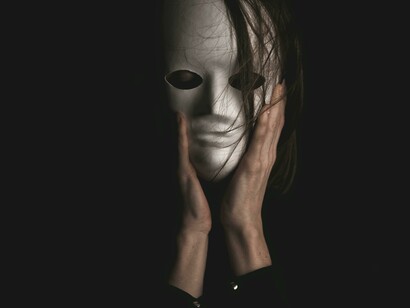 The white mask embodies how public personas can distort reality in leadership to manipulate others