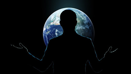 A man with open hands standing behind a globe, symbolizing global care and responsibility