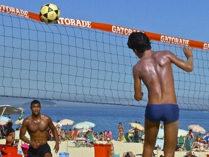 Futevôlei, cena comum nas praias do Rio de Janeiro. Nos primeiros anos, o Rio de Janeiro se desenvolveu lentamente, com base na agricultura de subsistência, no cultivo da cana-de-açúcar e na exportação de pau-brasil. A cidade crescia em torno do Morro do Castelo, ponto estratégico e seguro para defesa. Ao longo dos séculos XVII e XVIII, com a intensificação do tráfico de escravizados africanos, a cidade tornou-se um dos principais portos do comércio atlântico. Milhares de africanos foram trazidos à força para o Brasil pelo porto do Rio, marcando profundamente a cultura, a arquitetura e a população da cidade