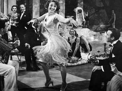 In the glow of a 1920s jazz club, this dancer’s flapper dress swings with every step, mirroring the energetic rhythms of jazz that revolutionised not only the music scene but also the fashion of the time