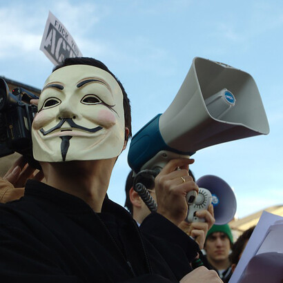 At Republic Square in Belgrade, Serbia, a man wearing a Guy Fawkes mask joins a protest opposing the ACTA treaty