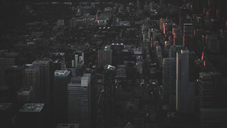 An aerial view of the city at night reveals a rare silence—its streets darkened by a widespread power outage