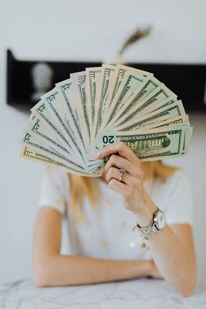 A person holding money in front of their face