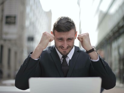 A man in a suit rejoicing over his latest success