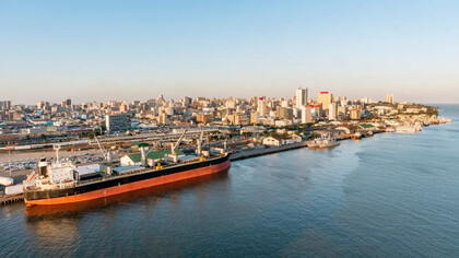 Vista panorâmica do porto de Maputo, com o horizonte urbano e as águas da baía em destaque. A dinâmica econômica moçambicana exige que as empresas adotem métodos quantitativos para controlar custos e tomar decisões mais precisas em ambientes de constante transformação