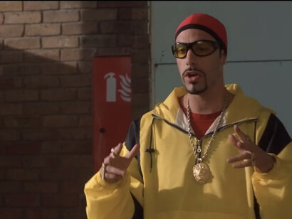 Ali G es idiota, pero no deja de ser un tipo bienintencionado que se mete en política para salvar el centro educativo en el que hace algo parecido a dar clase a los niños del barrio (y afeitar las cejas de los alumnos aventajados)