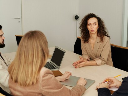 An office meeting and a woman attending a job interview