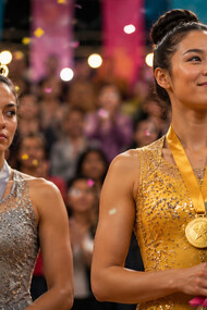 A silver medallist watching the gold winner with envy, representing the feeling of falling short despite success