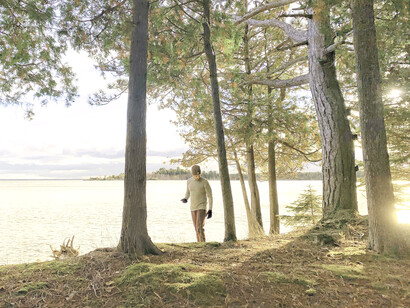 Hombre pasea por el bosque frente a un lago