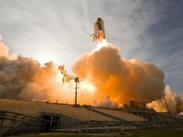 A rocket lifting off into the sky, representing SpaceX's next stage of growth