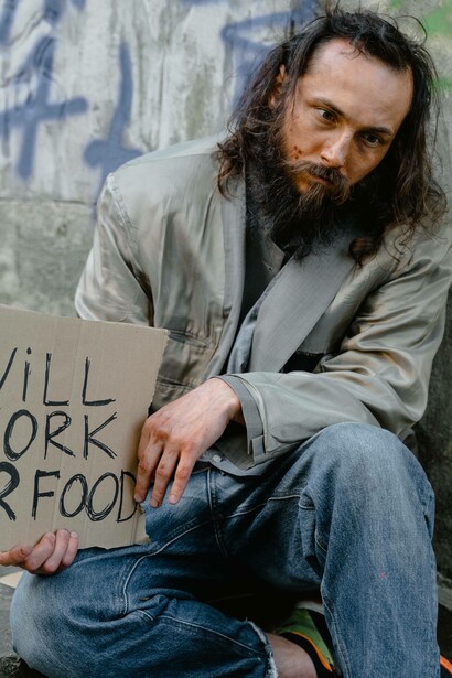 Homeless man with sign 'will work for food'