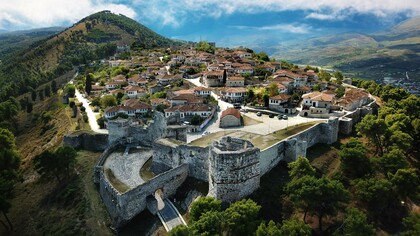 The fortified walls of Berat Castle surrounding a historic hillside neighborhood, highlighting the architectural heritage of Berat, Albania