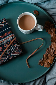 Una libreta de notas cerrada y vacía, junto a una tasa de café