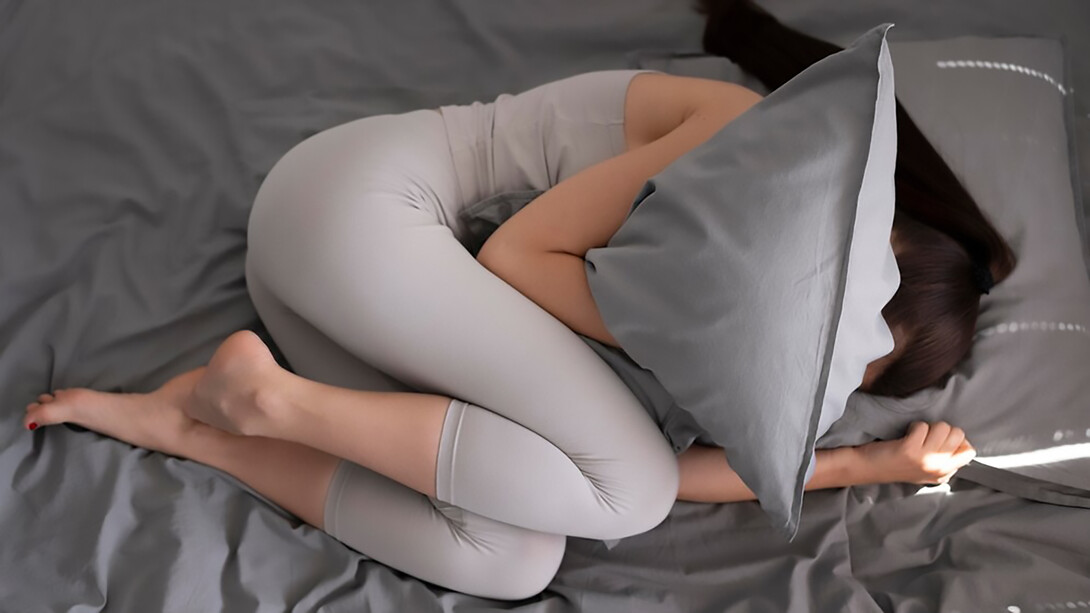 A woman tightly clutching a pillow, seeking a sense of comfort, solace, or emotional support