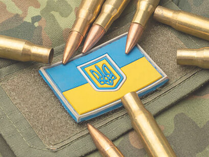 The Ukrainian flag's background showcases bullets, and the camouflage symbolizes the army's resilience