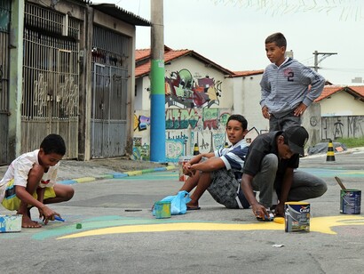 Jóvenes pintando en el asfalto de una calle de São Paulo