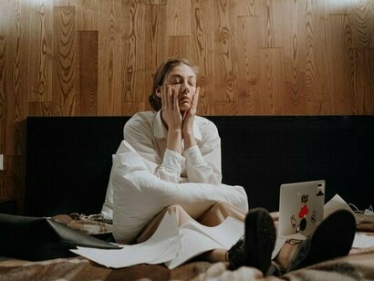 A woman pausing in the middle of work due to exhaustion, reflecting the constant trade-off between health limitations and external expectations