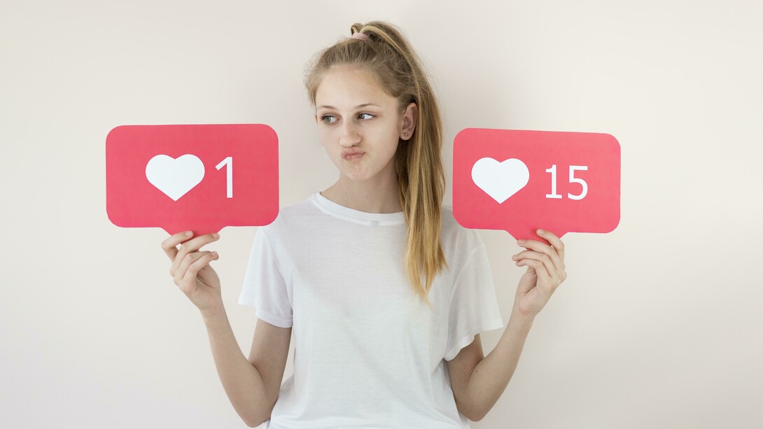 A girl posing with digital “like” symbols, illustrating online validation