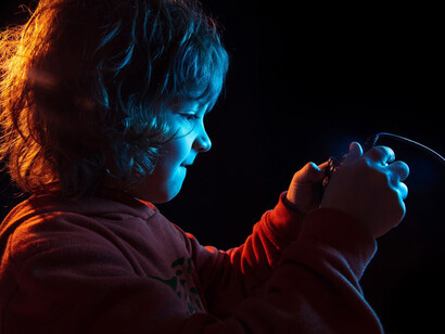 A boy playing video games, with a focus on digital safety, preventing online child abuse, and AI's role in protecting children online