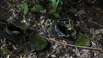 Fotografía de la exposición «Ríos y silencios»: zapatos encontrados en un campamento abandonado.