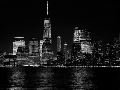 The Brooklyn Bridge illuminated at night, connecting Manhattan and Brooklyn in New York City
