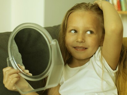 Menina se observa no espelho. Percebemos o quanto as formas de relacionamento na infância são responsáveis por moldar o que registramos na memória. “Uma criança é capaz de falar sobre o passado, mesmo antes de se lembrar dele”, é o que ressalta um artigo divulgado pelo The Guardian