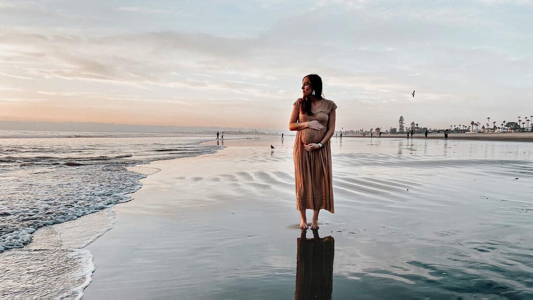 Mujer embarazada frente a la orilla de una playa 