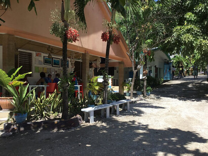 Locals and travelers alike pause under the shade of palms, the scent of salt in the air, their paths converging at the shoreline where land and story meet