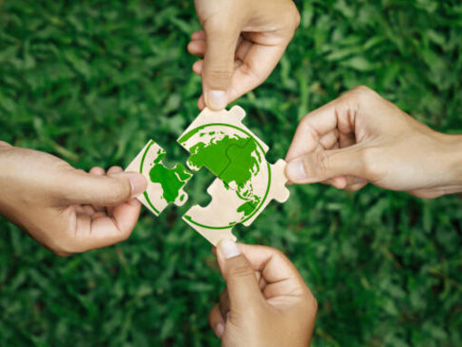 Through collaboration, businesses, corporations, and communities can drive progress toward environmental sustainability, with the paper globe representing their collective commitment