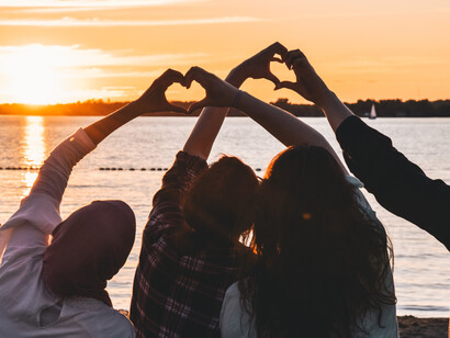 Friends holding hearts by the sea, the law of temporality and the biological being