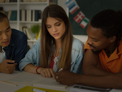 Students busy learning languages together while sitting at a table in a classroom