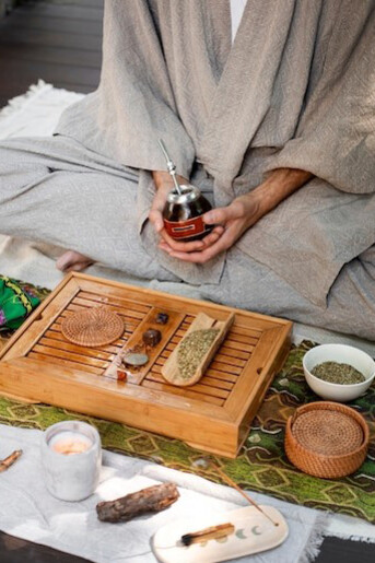 A man holding a cup outdoors, reflecting the principles of Ayurveda, genomics, personalized medicine, and the use of Ayurvedic herbs