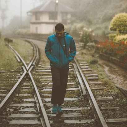 A man walks alone on foggy train tracks in Sri Lanka, symbolizing heartbreak and the feeling of being misunderstood